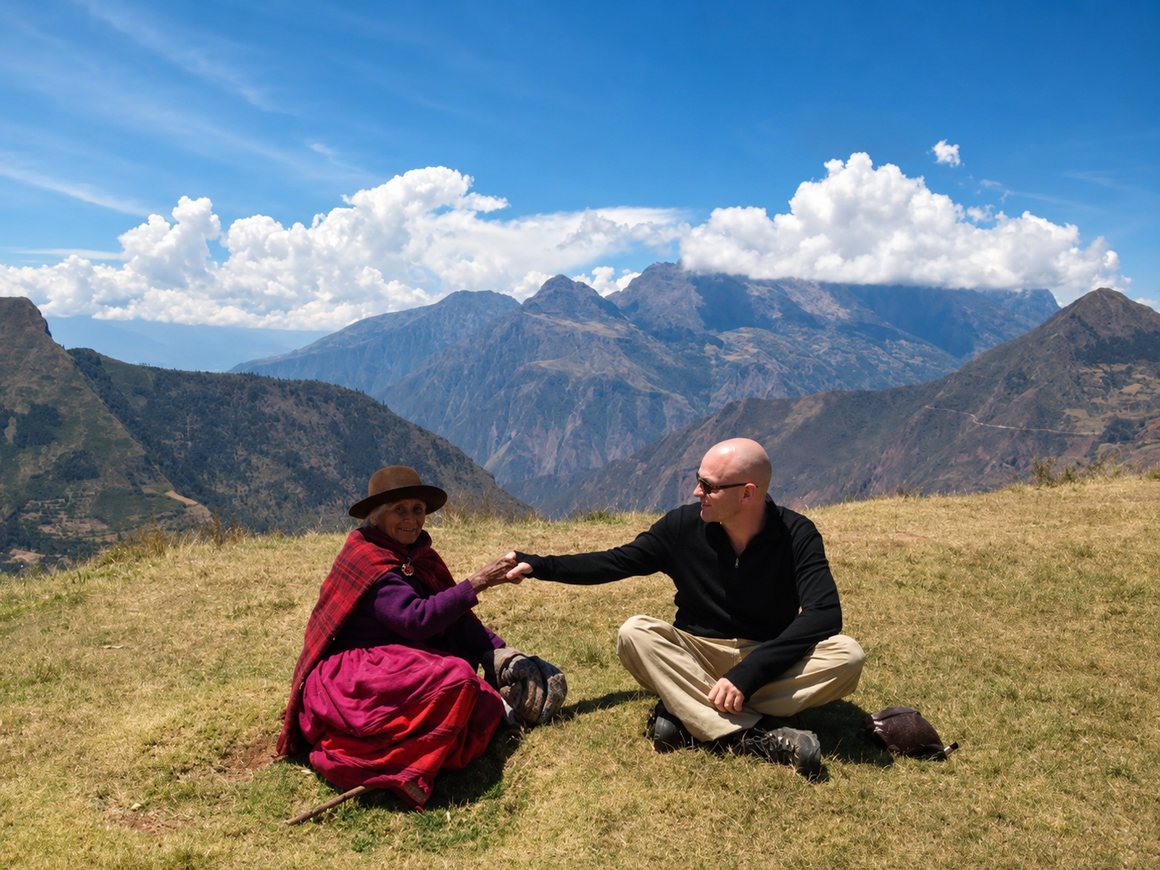 Gordon sitting with an elderly woman in the Peruvian Andes, holding her hand