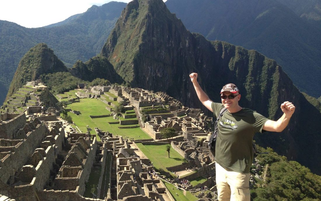 Gordon at Machu Picchu, arms raised at the summit