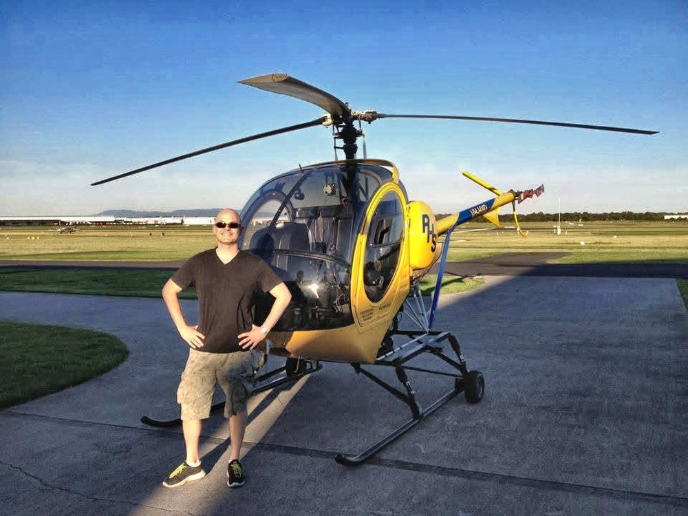 Gordon Smith beside the helicopter he flew on his first flight, an instructor alongside him