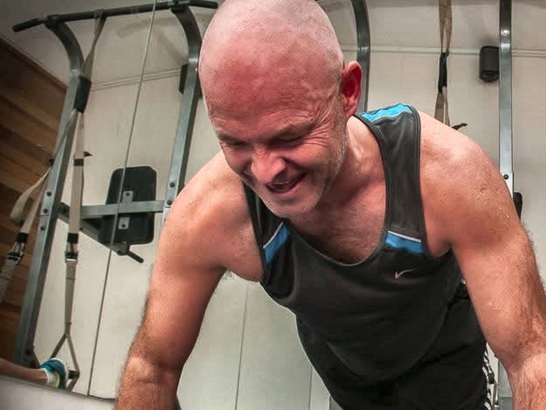 Gordon training in the gym, mid push-up — doing the work